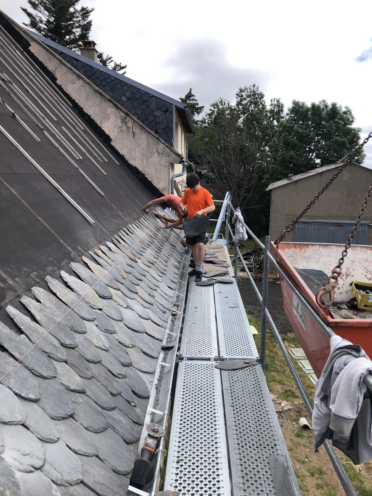 Couvreur posant de l’ardoise depuis un échafaudage