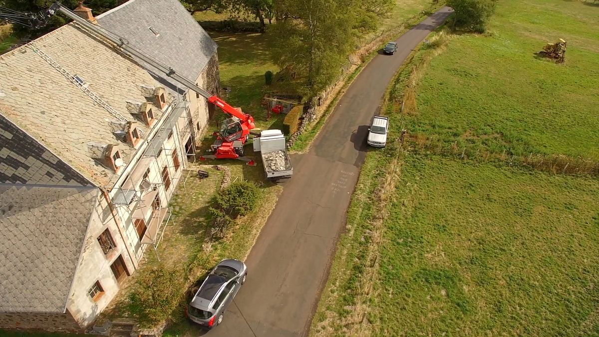 Vue aérienne d’une maison en pierre à lucarnes, toiture en cours de rénovation